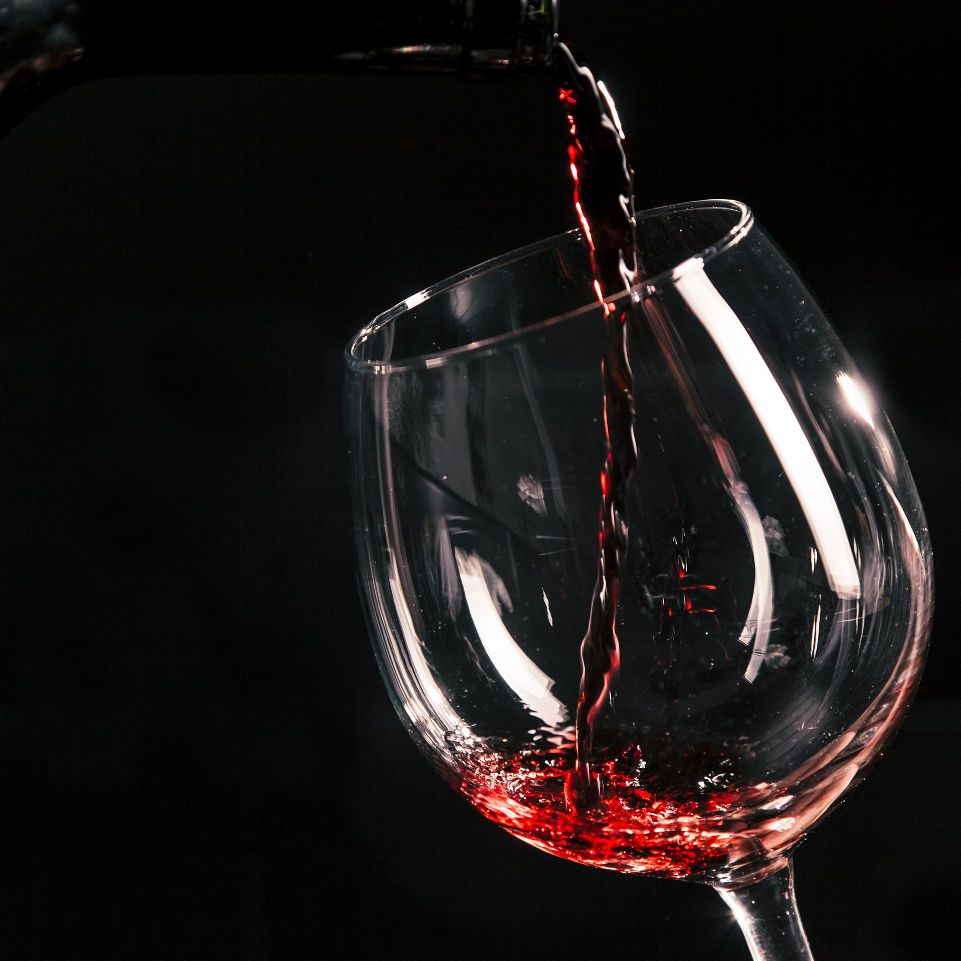 Wein wird ins Glas eingeschenkt