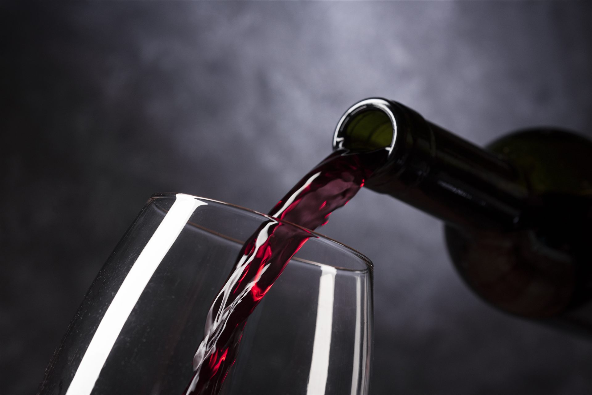 Rotwein wird ins Glas gegossen